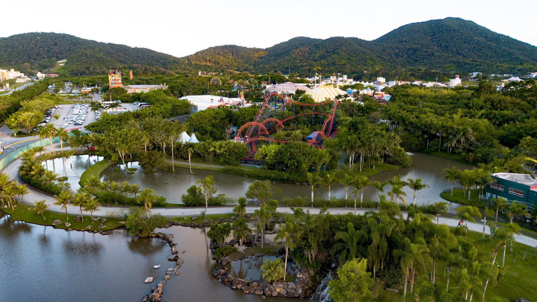 Vista aérea do parque em Penha, com lagos, coqueiros e montanha-russa entre a vegetação