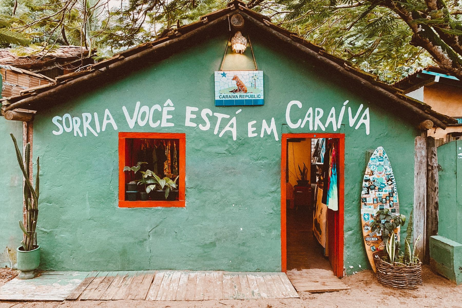 Fachada de casa verde em Caraíva com a frase "Sorria, você está em Caraíva"