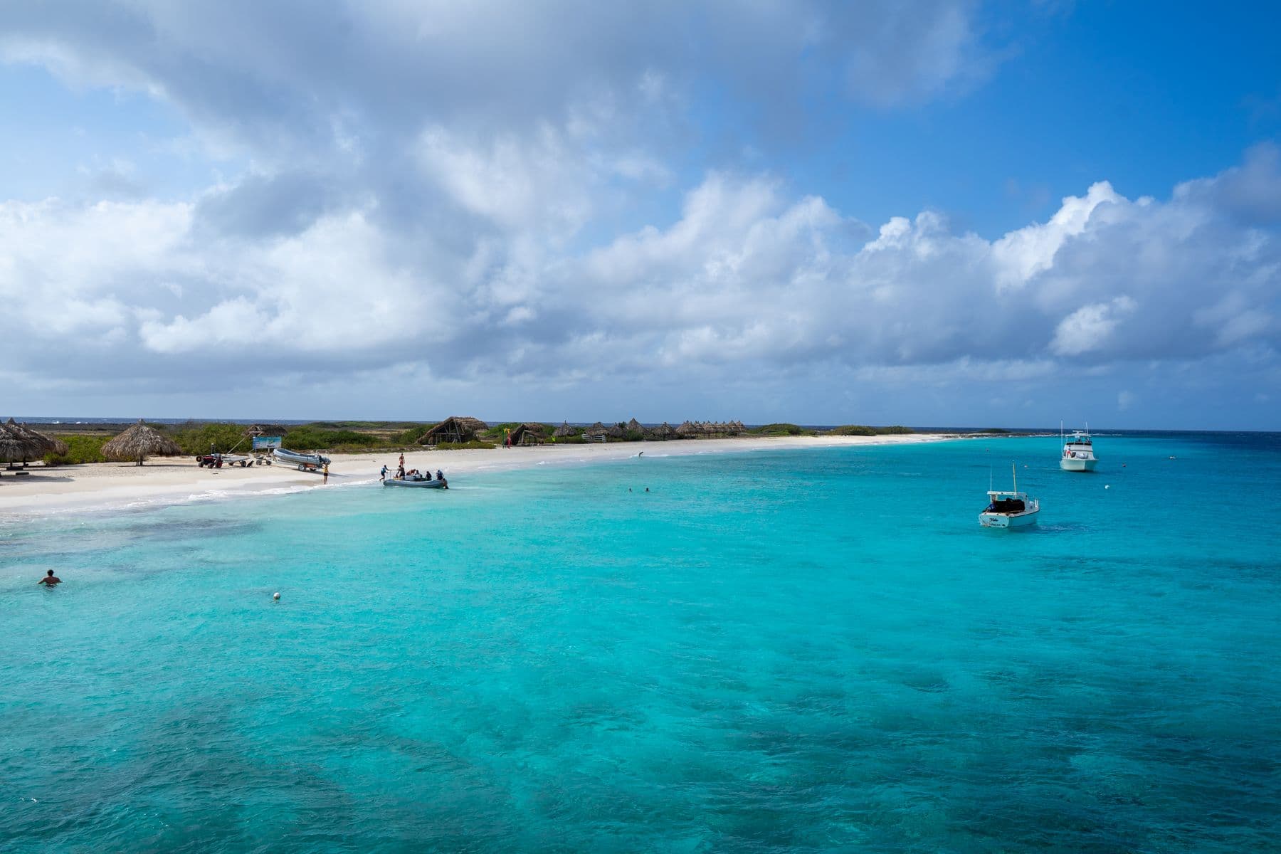 Enseada de águas azul-turquesa com barcos ancorados em Curaçao