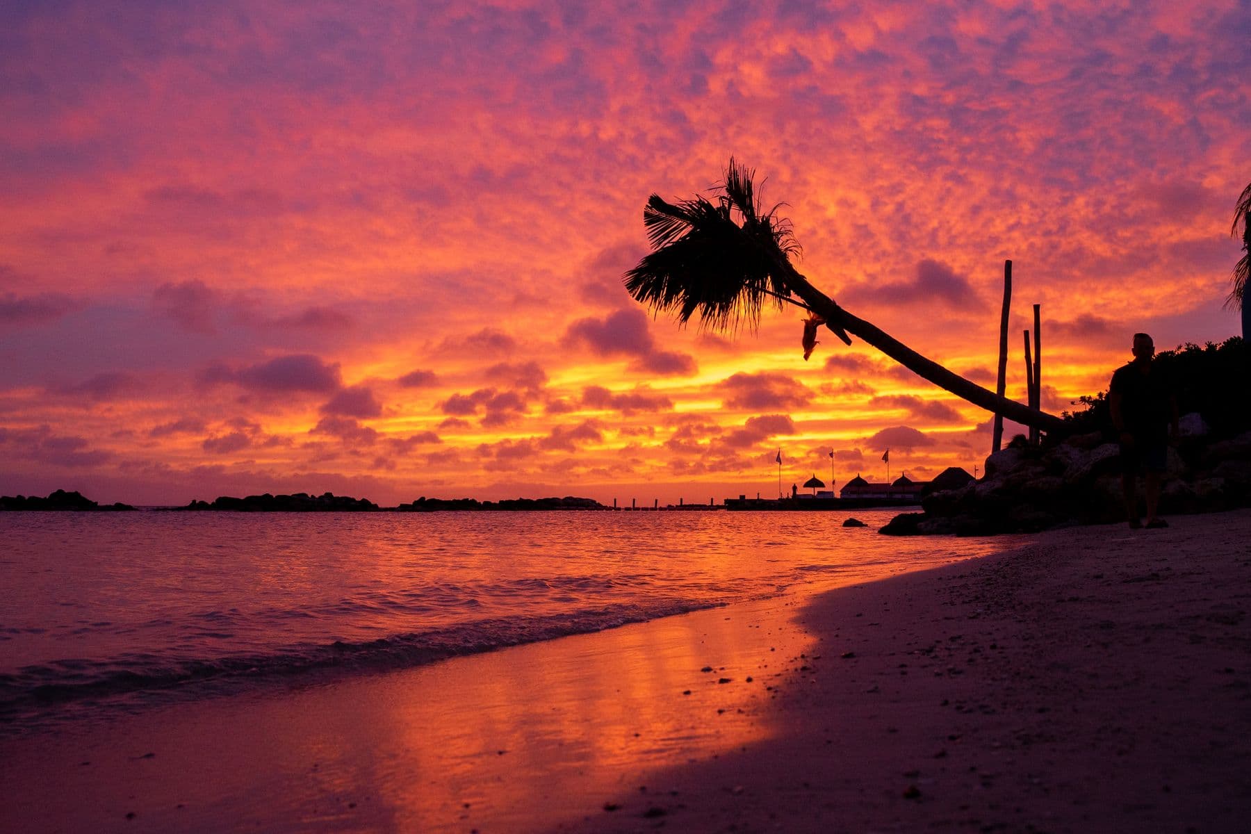 Pôr do sol alaranjado sobre uma praia tranquila em Curaçao