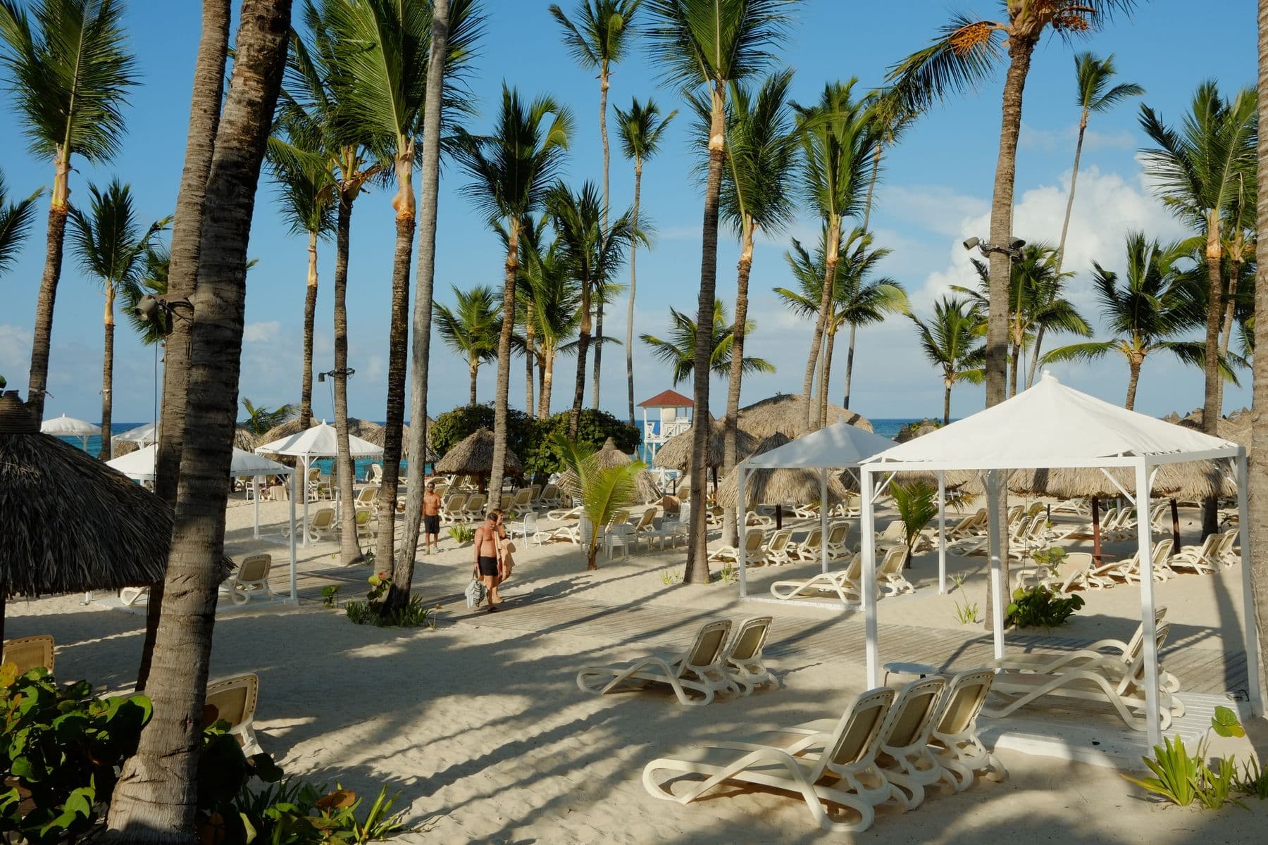 Espreguiçadeiras e gazebos entre coqueiros em resort de Punta Cana