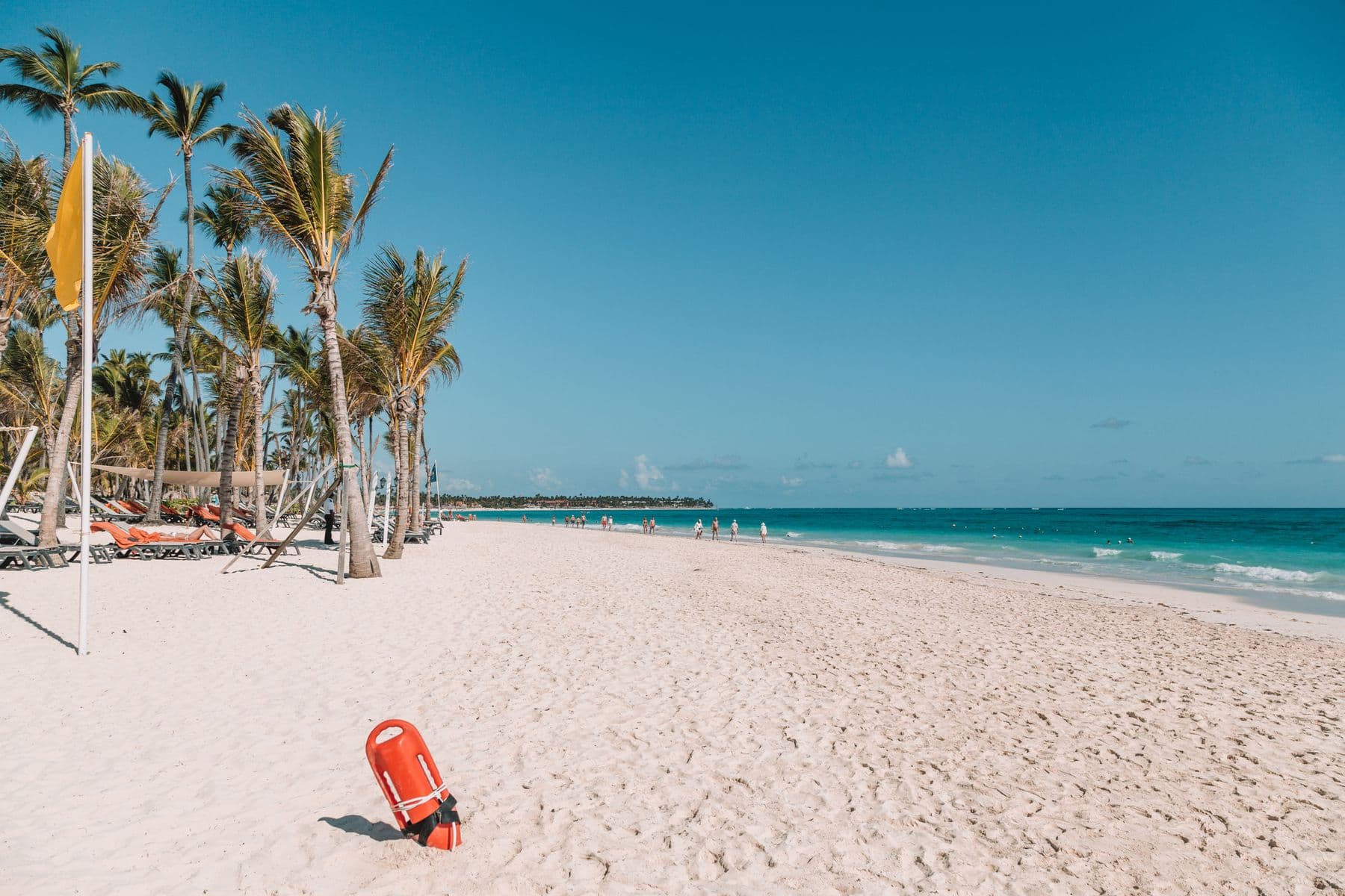 Praia ampla de areia branca cercada por coqueiros em Punta Cana