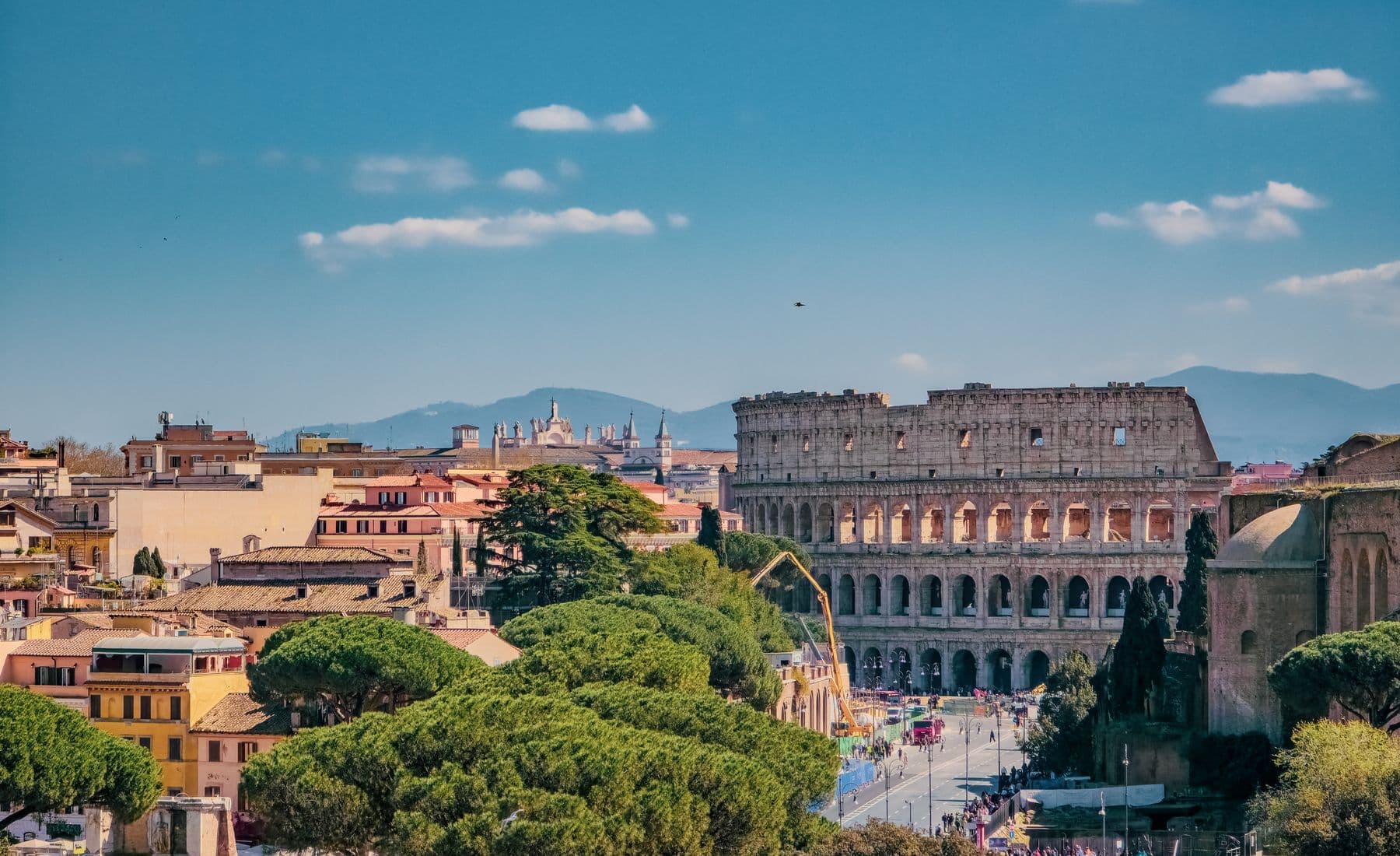 Coliseu e paisagem urbana de Roma sob o céu azul